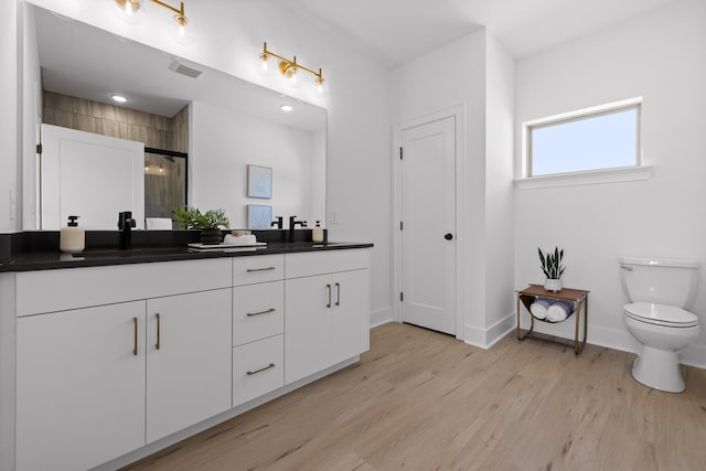 2522 E 18th St, Chattanooga, TN 37404 - full bath featuring double vanity, a shower stall, toilet, wood finished floors, and baseboards