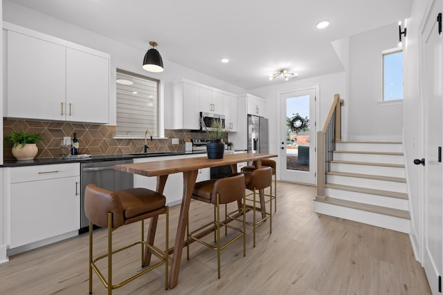 2522 E 18th St, Chattanooga, TN 37404 - kitchen with appliances with stainless steel finishes, tasteful backsplash, a sink, light wood-style flooring, and recessed lighting