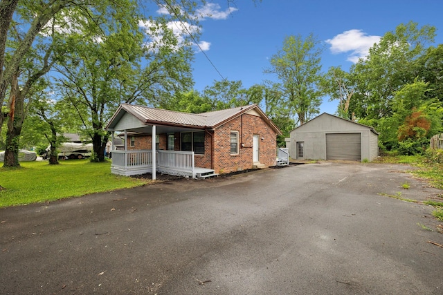 120 Johns St, La Vergne, TN 37086 - view of front facade with a garage, covered porch, brick siding, an outdoor structure, and metal roof