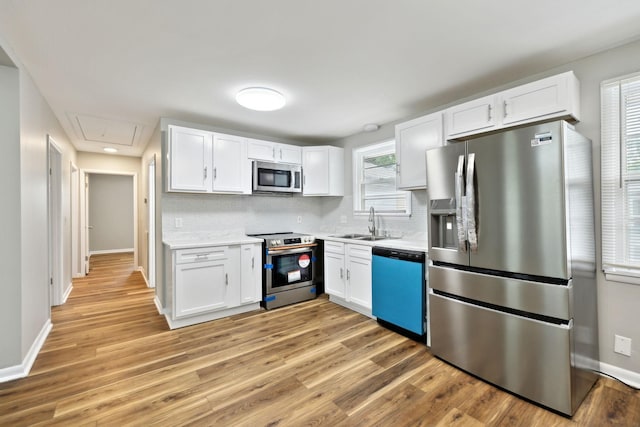 120 Johns St, La Vergne, TN 37086 - kitchen featuring appliances with stainless steel finishes, a sink, light countertops, and white cabinetry