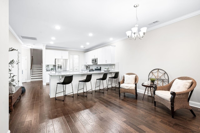 3023 Moultrie Cir, Franklin, TN 37064 - kitchen featuring appliances with stainless steel finishes, a peninsula, crown molding, dark wood finished floors, and baseboards