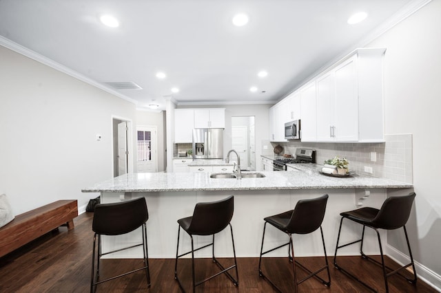 3023 Moultrie Cir, Franklin, TN 37064 - kitchen featuring appliances with stainless steel finishes, a sink, a peninsula, crown molding, and white cabinetry