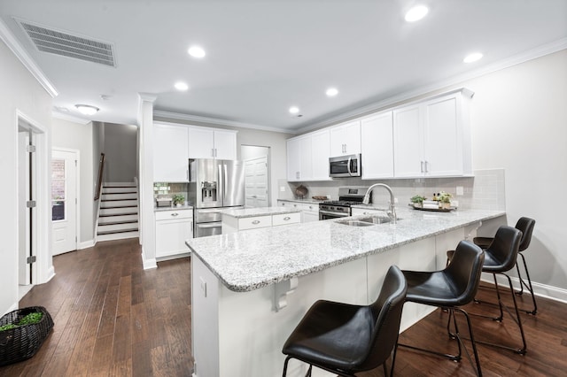 3023 Moultrie Cir, Franklin, TN 37064 - kitchen featuring appliances with stainless steel finishes, a sink, ornamental molding, a peninsula, and a kitchen breakfast bar