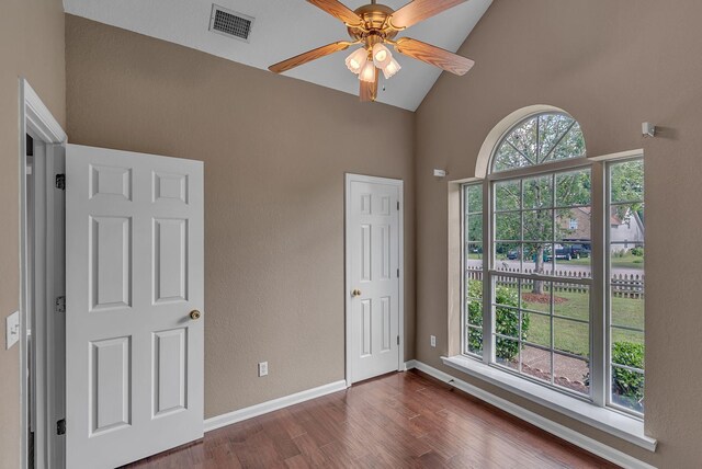 2240 Joann Dr, Spring Hill, TN 37174 - unfurnished bedroom featuring multiple windows, dark wood-style floors, high vaulted ceiling, baseboards, and a ceiling fan