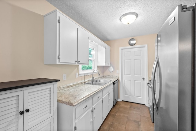 3387 Oak Park Dr, Clarksville, TN 37042 - kitchen with stainless steel appliances, a sink, a textured ceiling, light countertops, and white cabinets