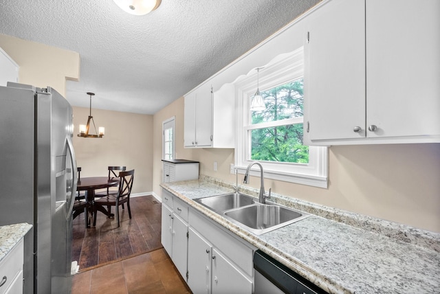 3387 Oak Park Dr, Clarksville, TN 37042 - kitchen with appliances with stainless steel finishes, a sink, white cabinets, light countertops, and a textured ceiling