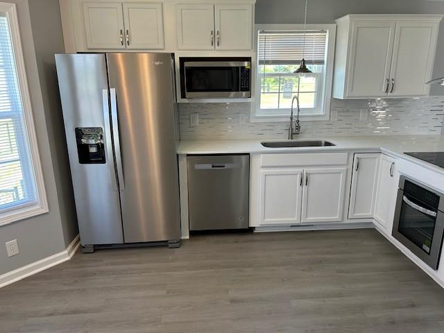 1047 Tylertown Rd, Clarksville, TN 37040 - kitchen featuring stainless steel appliances, a sink, tasteful backsplash, white cabinetry, and light wood-style flooring