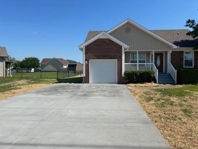 1047 Tylertown Rd, Clarksville, TN 37040 - single story home featuring covered porch, an attached garage, brick siding, and driveway