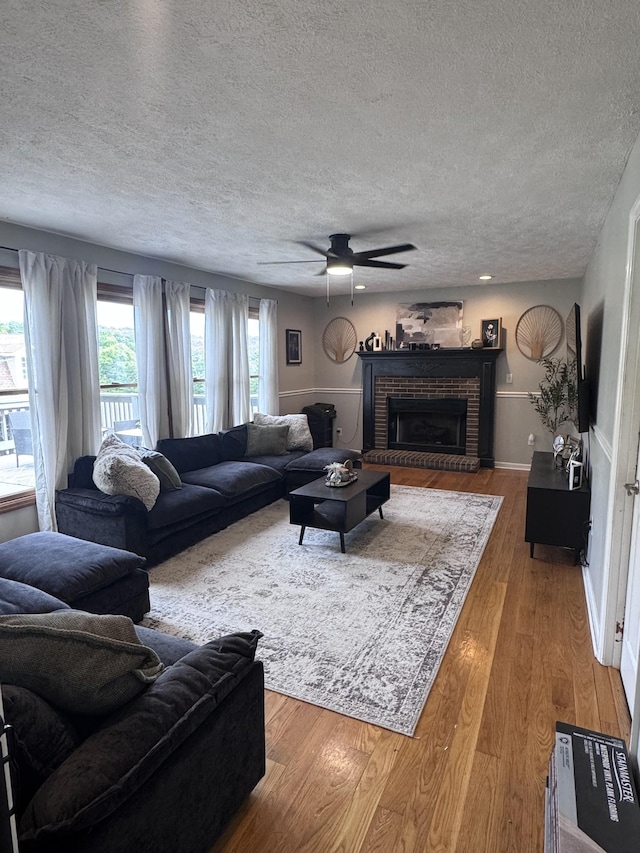 1111 Craig Moore Rd, Lewisburg, TN 37091 - living area with a textured ceiling, ceiling fan, wood finished floors, and a fireplace