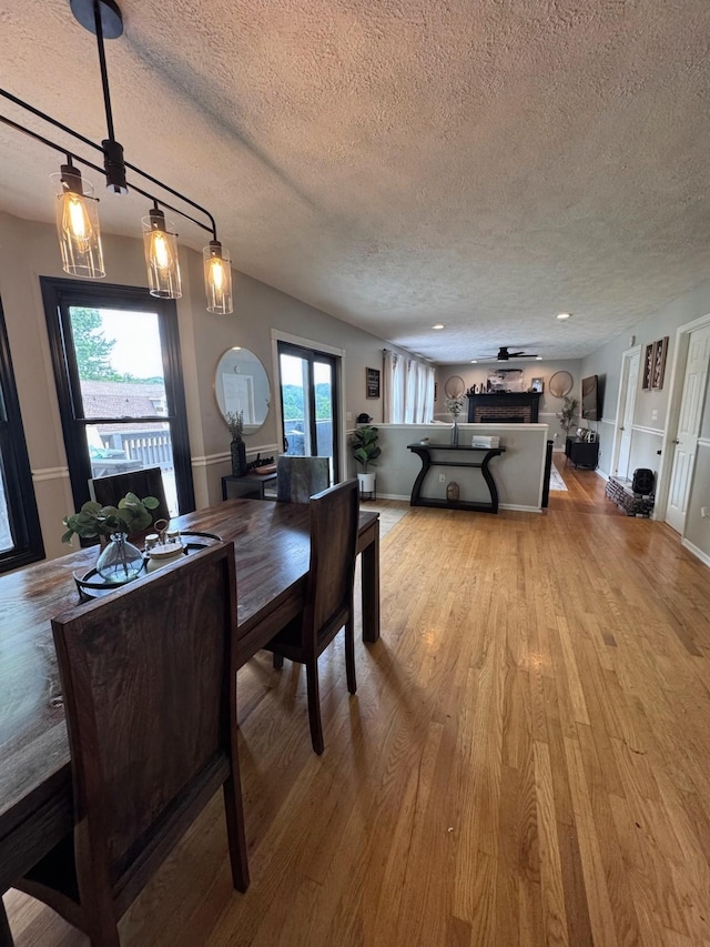 1111 Craig Moore Rd, Lewisburg, TN 37091 - dining space with a textured ceiling, a fireplace, light wood-style flooring, and a ceiling fan