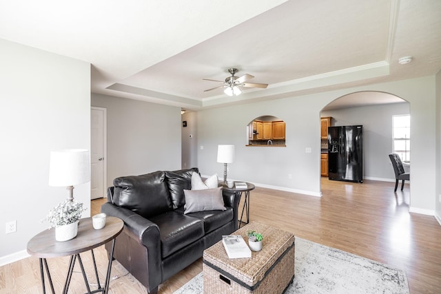 103 Alice Smith Dr, Portland, TN 37148 - living area featuring a tray ceiling, arched walkways, a ceiling fan, baseboards, and light wood-style flooring