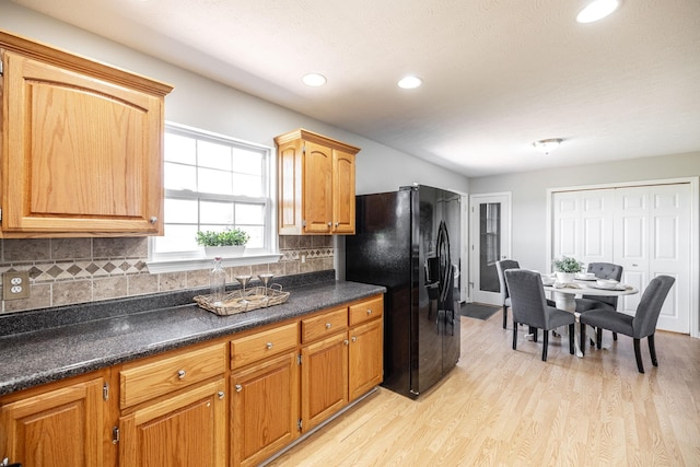 103 Alice Smith Dr, Portland, TN 37148 - kitchen with black refrigerator with ice dispenser, dark countertops, light wood finished floors, backsplash, and recessed lighting