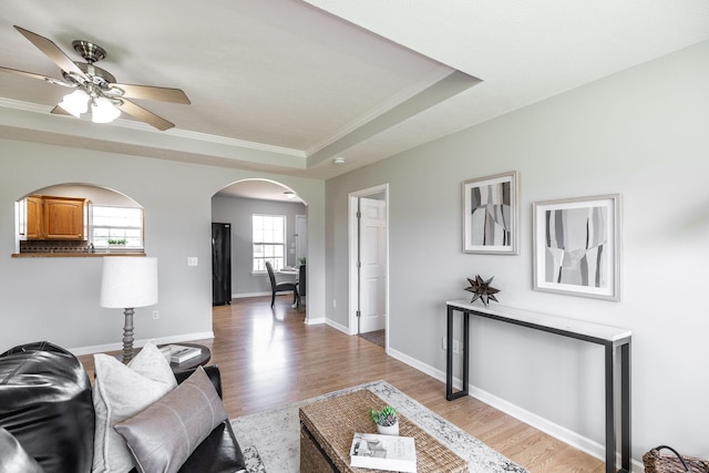 103 Alice Smith Dr, Portland, TN 37148 - living area with a ceiling fan, a raised ceiling, arched walkways, crown molding, and light wood-type flooring