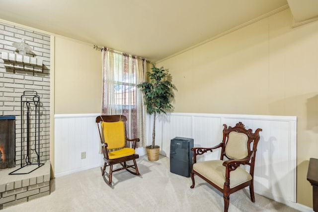 101 Townview Dr, Smyrna, TN 37167 - living area featuring a brick fireplace, carpet, wainscoting, a decorative wall, and crown molding