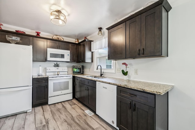 101 Townview Dr, Smyrna, TN 37167 - kitchen with white appliances, a sink, dark brown cabinets, light wood-style flooring, and light stone countertops