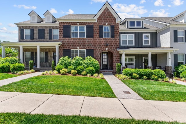 369 Carriage House Ln Unit L509, Hendersonville, TN 37075 - townhome / multi-family property with covered porch, board and batten siding, a front yard, and brick siding