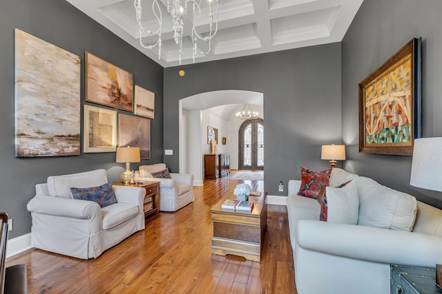 1120 Natchez Valley Ln, Franklin, TN 37064 - living area with arched walkways, a chandelier, coffered ceiling, light wood-style floors, and beam ceiling