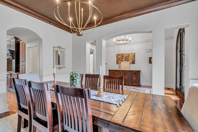1120 Natchez Valley Ln, Franklin, TN 37064 - dining room with a chandelier, arched walkways, crown molding, and light wood-style flooring