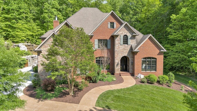 1120 Natchez Valley Ln, Franklin, TN 37064 - view of front facade with stone siding, a chimney, a front yard, and brick siding