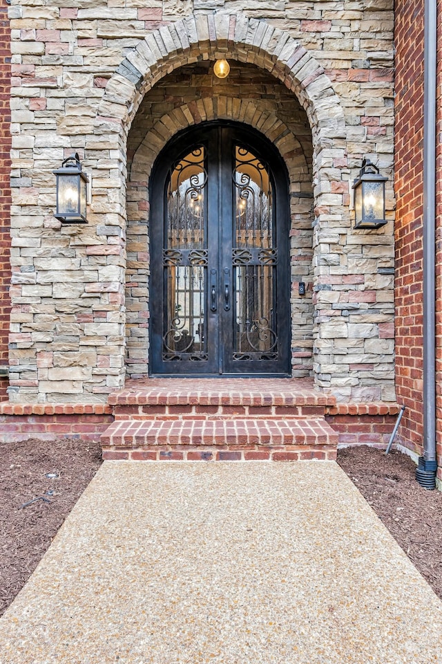 1120 Natchez Valley Ln, Franklin, TN 37064 - view of exterior entry featuring brick siding, stone siding, and french doors