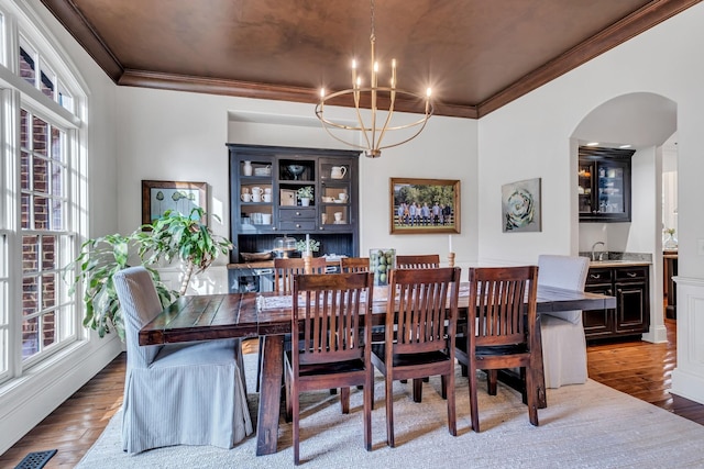1120 Natchez Valley Ln, Franklin, TN 37064 - dining space with ornamental molding, plenty of natural light, arched walkways, a chandelier, and wood finished floors