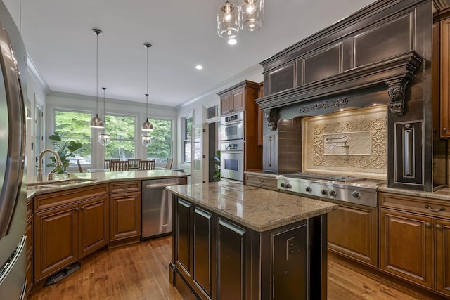 1120 Natchez Valley Ln, Franklin, TN 37064 - kitchen featuring stainless steel appliances, a sink, a kitchen island, light stone countertops, and wood-type flooring