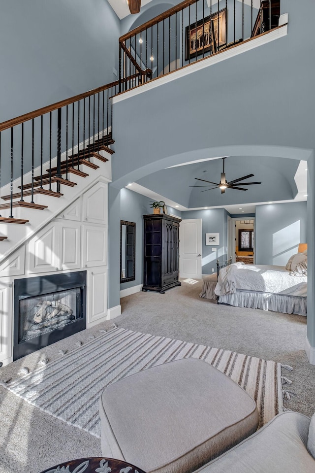 1120 Natchez Valley Ln, Franklin, TN 37064 - carpeted living room with baseboards, arched walkways, a ceiling fan, a high ceiling, and stairway