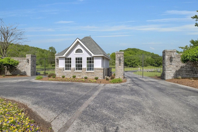 1120 Natchez Valley Ln, Franklin, TN 37064 - view of front of house featuring a gate, stucco siding, stone siding, and asphalt driveway