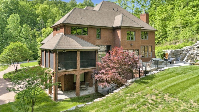 1120 Natchez Valley Ln, Franklin, TN 37064 - rear view of property featuring a patio, a chimney, a yard, a shingled roof, and brick siding