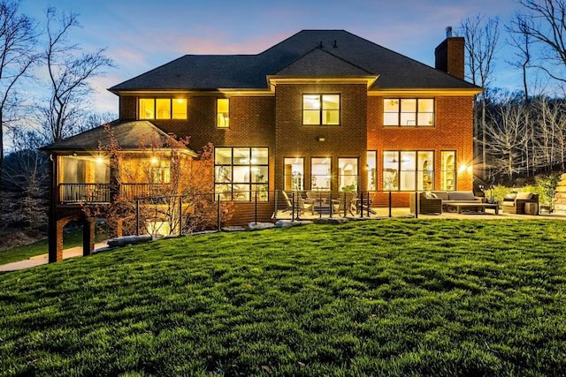 1120 Natchez Valley Ln, Franklin, TN 37064 - back of house at dusk with outdoor lounge area, a chimney, a yard, and a patio