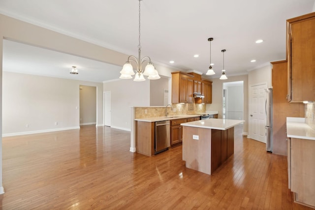 1120 Banbury Ln, Brentwood, TN 37027 - kitchen featuring stainless steel appliances, crown molding, brown cabinetry, decorative backsplash, and light countertops