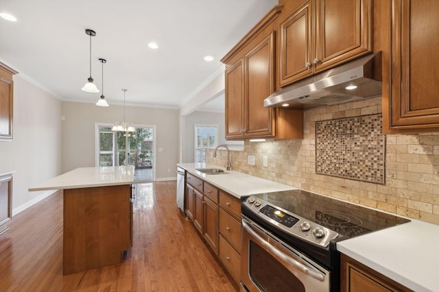 1120 Banbury Ln, Brentwood, TN 37027 - kitchen featuring appliances with stainless steel finishes, a sink, under cabinet range hood, brown cabinetry, and ornamental molding