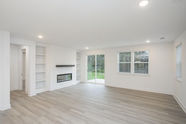 118 W Cassa Way, Mount Juliet, TN 37122 - unfurnished living room with light wood-style floors, built in features, baseboards, a glass covered fireplace, and recessed lighting