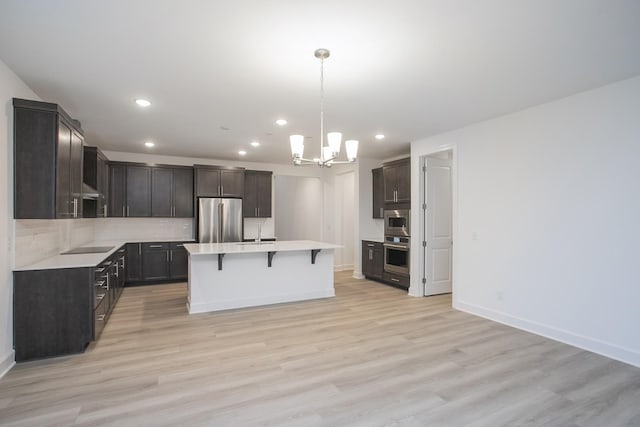 118 W Cassa Way, Mount Juliet, TN 37122 - kitchen with appliances with stainless steel finishes, a chandelier, a breakfast bar area, light countertops, and light wood-type flooring