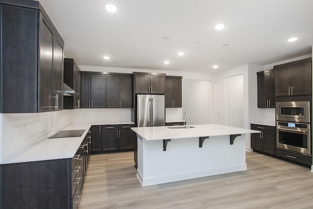 118 W Cassa Way, Mount Juliet, TN 37122 - kitchen with stainless steel appliances, a breakfast bar area, light wood-style floors, recessed lighting, and a sink