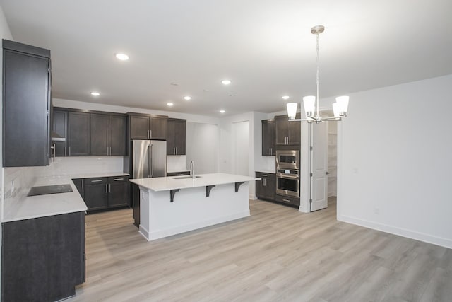 118 W Cassa Way, Mount Juliet, TN 37122 - kitchen with stainless steel appliances, a sink, recessed lighting, light wood-style floors, and a kitchen breakfast bar