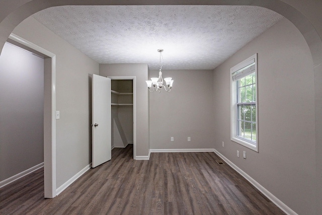 104 Evanmeade Dr, Smyrna, TN 37167 - unfurnished dining area featuring arched walkways, dark wood-style floors, baseboards, a chandelier, and a textured ceiling