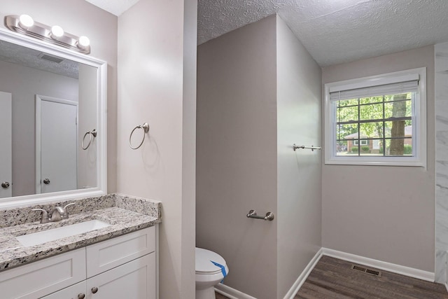 104 Evanmeade Dr, Smyrna, TN 37167 - bathroom featuring toilet, vanity, wood finished floors, a textured ceiling, and baseboards