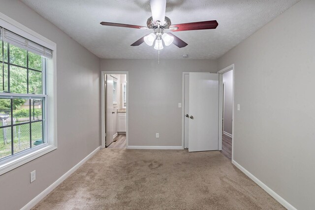 104 Evanmeade Dr, Smyrna, TN 37167 - unfurnished bedroom with carpet flooring, baseboards, ensuite bathroom, a textured ceiling, and ceiling fan