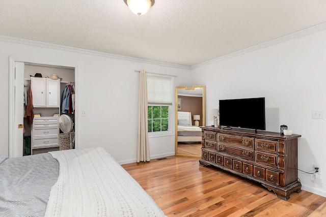 24 Hillcrest Dr, Sparta, TN 38583 - bedroom featuring ornamental molding, light wood finished floors, baseboards, a walk in closet, and a closet