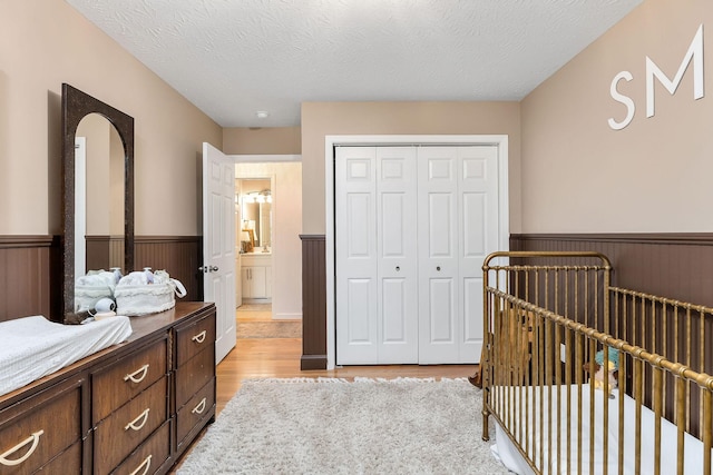 24 Hillcrest Dr, Sparta, TN 38583 - bedroom with wainscoting, light wood finished floors, a closet, and a textured ceiling