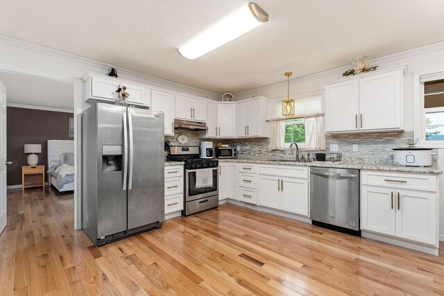24 Hillcrest Dr, Sparta, TN 38583 - kitchen featuring appliances with stainless steel finishes, under cabinet range hood, ornamental molding, tasteful backsplash, and white cabinets