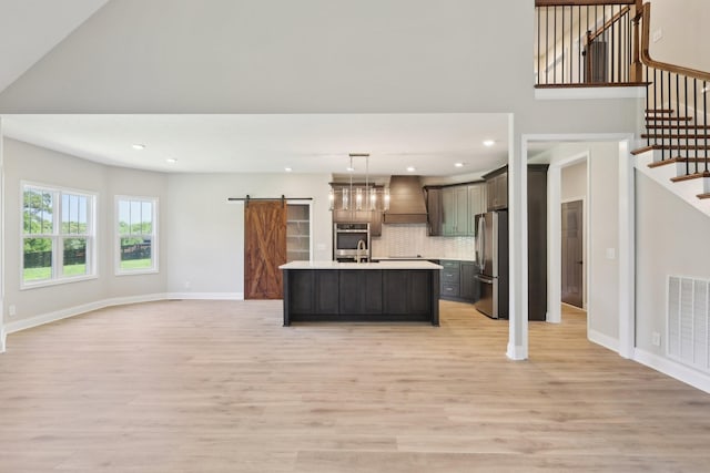 1373 Southside Rd, Southside, TN 37171 - kitchen with appliances with stainless steel finishes, a barn door, open floor plan, light countertops, and recessed lighting