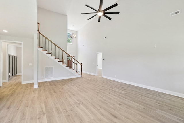 1373 Southside Rd, Southside, TN 37171 - unfurnished living room featuring stairs, light wood-style floors, a ceiling fan, a chandelier, and baseboards