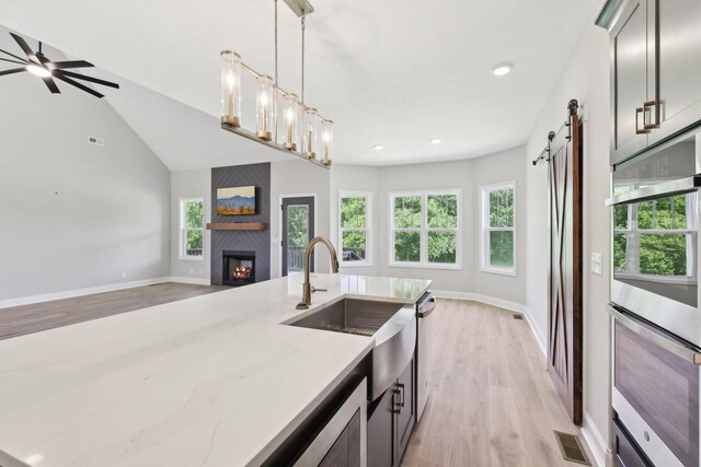1373 Southside Rd, Southside, TN 37171 - kitchen with open floor plan, a sink, light wood finished floors, light stone counters, and a barn door