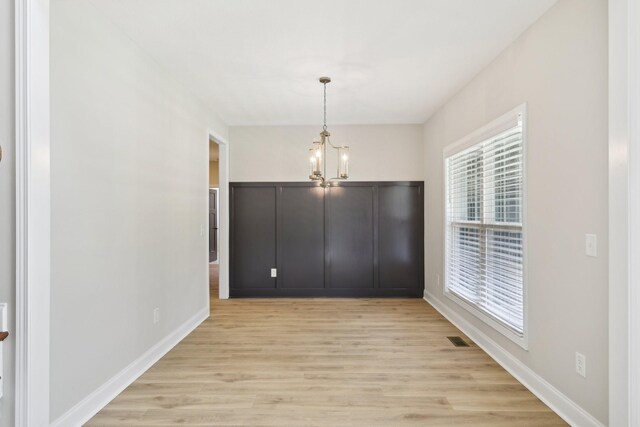 1373 Southside Rd, Southside, TN 37171 - unfurnished dining area with light wood-style flooring, plenty of natural light, a chandelier, and baseboards
