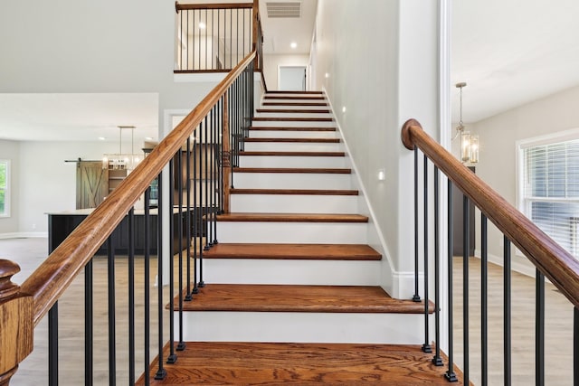 1373 Southside Rd, Southside, TN 37171 - staircase featuring wood finished floors, baseboards, and a chandelier