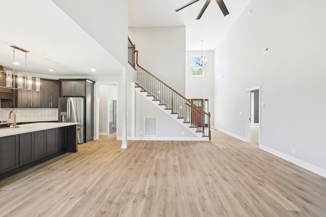 1373 Southside Rd, Southside, TN 37171 - kitchen with stainless steel refrigerator with ice dispenser, light countertops, a chandelier, light wood-style flooring, and backsplash