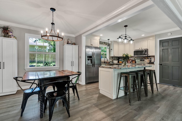 1430 Blythe Ferry Rd NE, Cleveland, TN 37312 - kitchen featuring appliances with stainless steel finishes, a chandelier, a center island, white cabinetry, and wood finished floors
