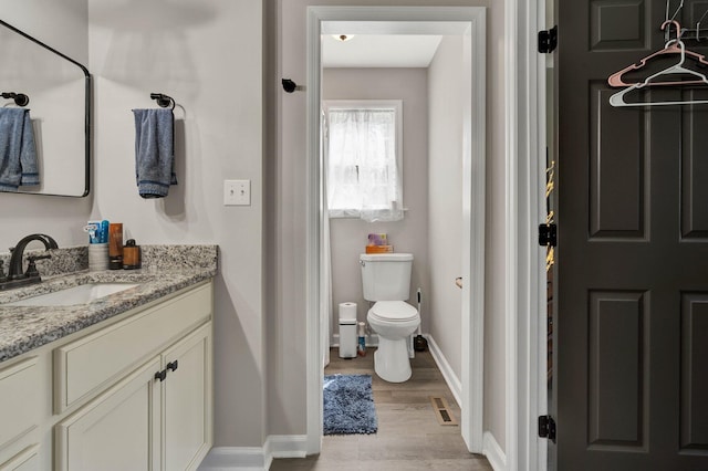 1430 Blythe Ferry Rd NE, Cleveland, TN 37312 - bathroom with toilet, vanity, wood finished floors, and baseboards